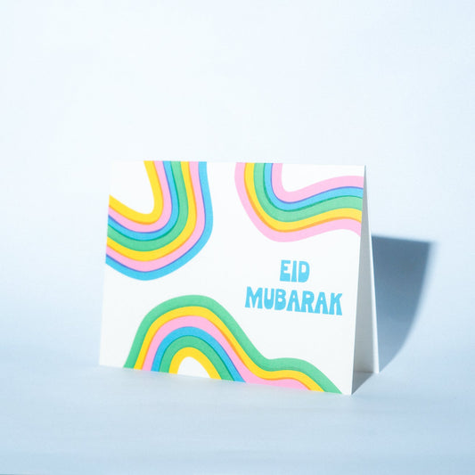 Greeting card with colorful design and 'Eid Mubarak' text on a light blue background