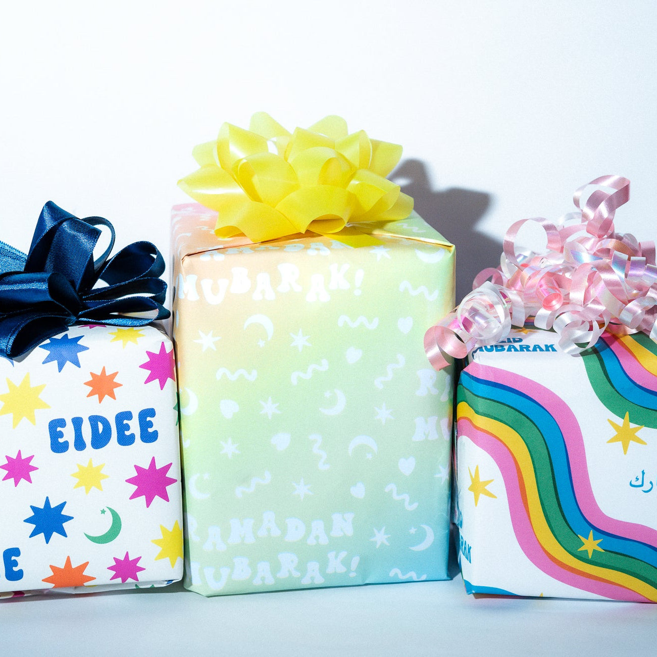 Three colorful gift boxes with decorative bows on a white background