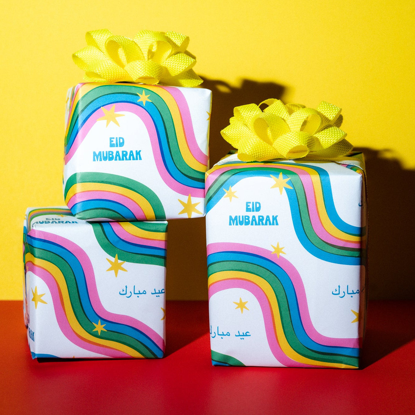 Three gift boxes with colorful designs and 'Ed Mubarak' text on a yellow and red background